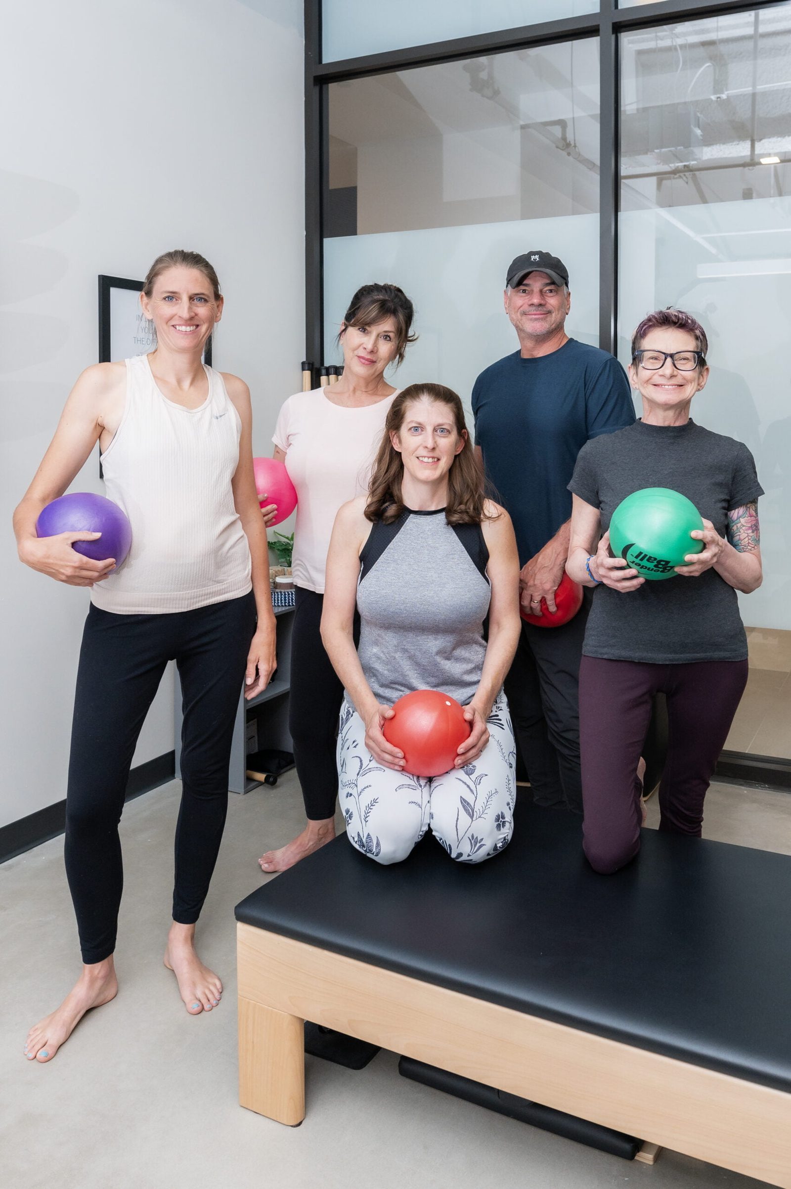 The Denver Pilates Girl community holding stability balls in the studio